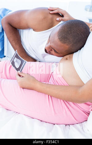 Moglie incinta che mostra sonogram al marito Foto Stock