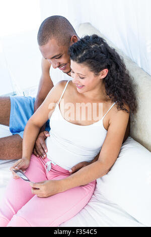 Felice moglie incinta che mostra sonogram al marito Foto Stock