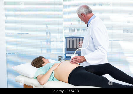Medico che mostra i risultati di ultrasuoni alla donna in stato di gravidanza Foto Stock