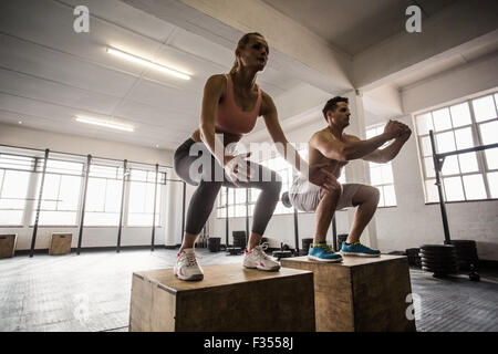 Coppia muscolare facendo il salto squat Foto Stock