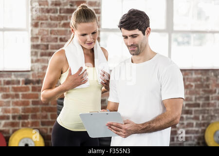 La donna a discutere la sua performance sul clipboard con trainer Foto Stock