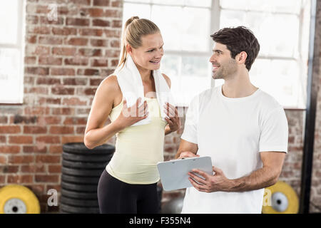 La donna a discutere la sua performance sul clipboard con trainer Foto Stock