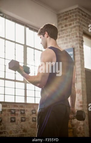 Vista posteriore del uomo focalizzato il sollevamento pesi Foto Stock