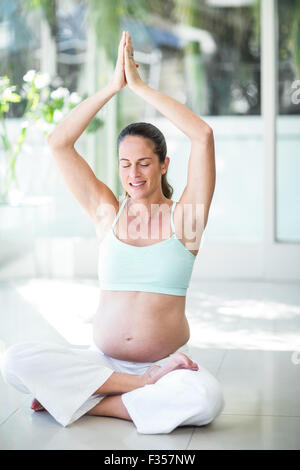 Donna felice meditando sul pavimento Foto Stock