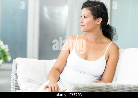 Felice donna seduta sul divano Foto Stock