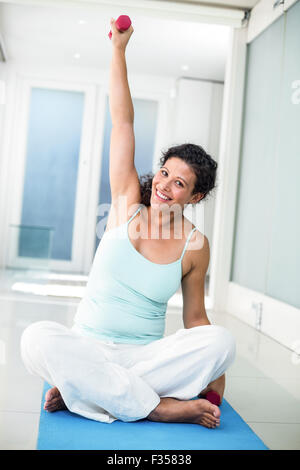 Ritratto di una donna incinta di peso di sollevamento Foto Stock