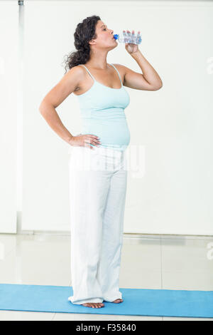Donna incinta acqua potabile da bottiglia Foto Stock