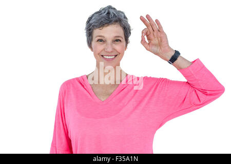 Felice donna matura che mostra segno OK Foto Stock