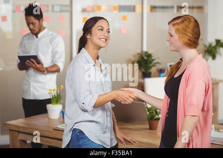 Felice imprenditrici stringono le mani in office Foto Stock