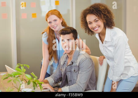 Sorridente la gente di affari con computer portatile Foto Stock