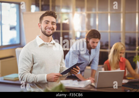 Fiducioso imprenditore utilizzando PC digitale con i colleghi di lavoro Foto Stock