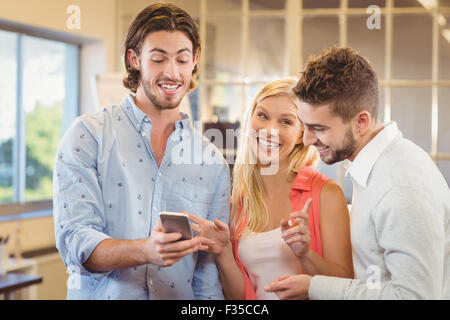 Imprenditore mostrando qualcosa su smart phone ai colleghi Foto Stock