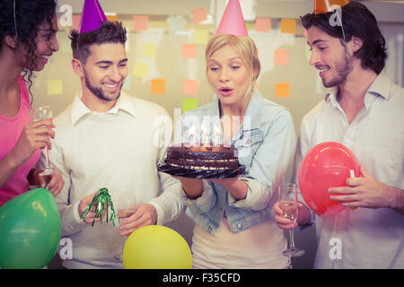 Imprenditrice soffiando candeline di compleanno Foto Stock