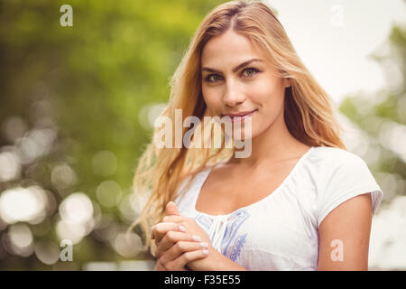 Ritratto di donna sorridente con le mani incrociate Foto Stock