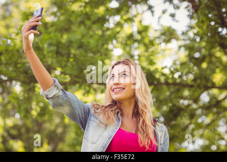 Donna sorridente tenendo selfie Foto Stock