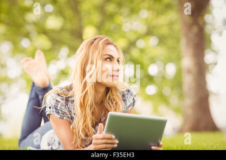 Donna sorridente azienda digitale compressa in posizione di parcheggio Foto Stock