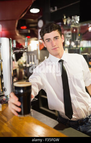 Ritratto del barista maschio che serve birra Foto Stock