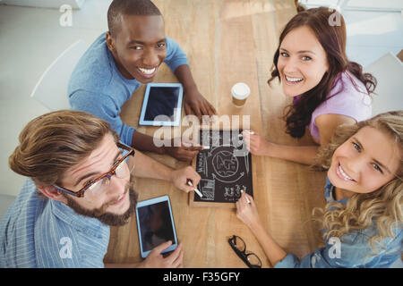 Ritratto di overhead di sorridere la gente di affari di scrittura termini aziendali sull'ardesia Foto Stock