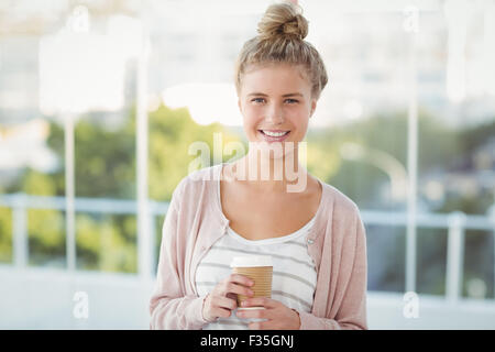 Ritratto di donna sorridente holding tazza da caffè Foto Stock