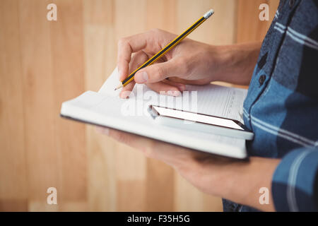 Immagine ritagliata di imprenditore iscritto con la matita sul libro Foto Stock