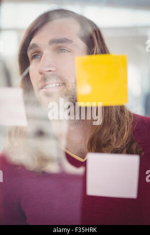 Imprenditore fiducioso in piedi di fronte a sticky notes Foto Stock