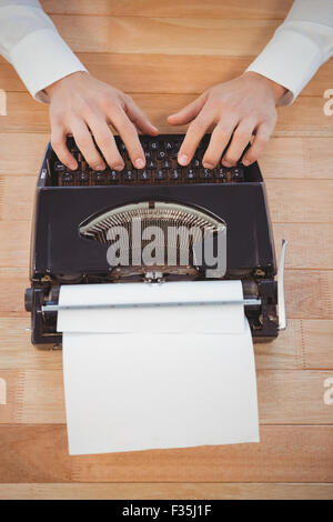 Imprenditore lavora su una macchina da scrivere a tavola in office Foto Stock
