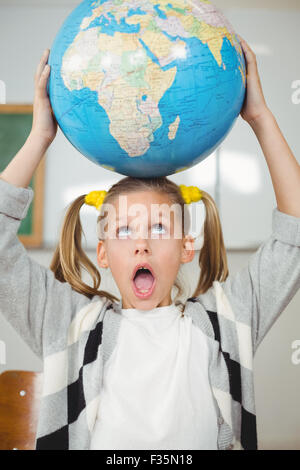 Carino pupilla globo di bilanciamento sulla testa in una classe Foto Stock
