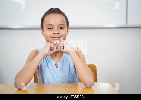 Studente sorridente appoggiato la testa nelle sue mani Foto Stock