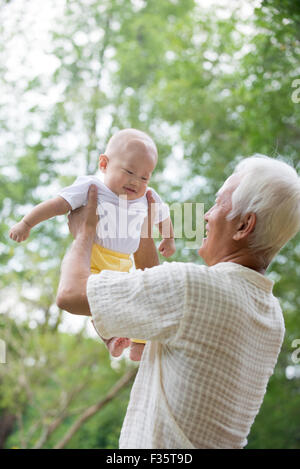 Cinese asiatici il nonno e nipote divertendosi al giardino esterno. Foto Stock