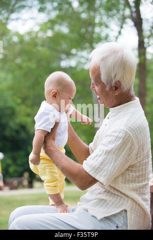 Cinese asiatici il nonno e nipote divertendosi al giardino esterno. Foto Stock