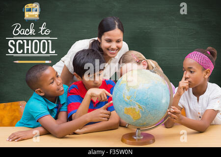 Immagine composita di graziosi gli alunni e gli insegnanti guardando il globo in biblioteca Foto Stock