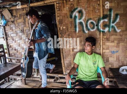 Un rifugiato kachin suona la chitarra in un campo di rifugiati in stato Kachin, Myanmar Foto Stock