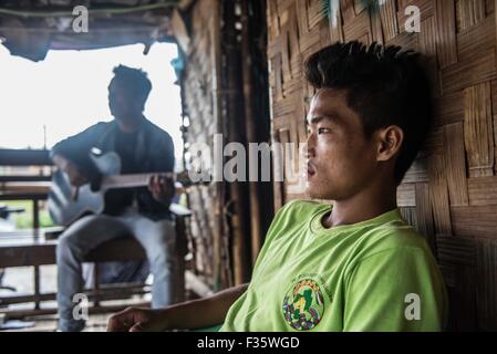 Un rifugiato kachin suona la chitarra in un campo di rifugiati in stato Kachin, Myanmar Foto Stock