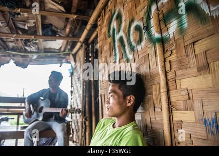 Un rifugiato kachin suona la chitarra in un campo di rifugiati in stato Kachin, Myanmar Foto Stock