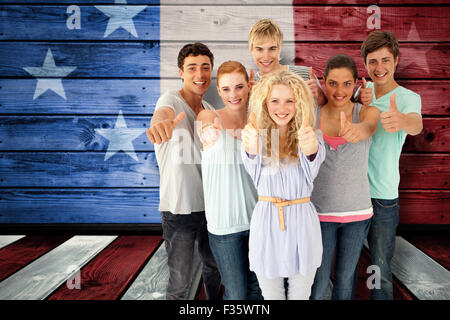 Immagine composita del gruppo di adolescenti in piedi nella parte anteriore della fotocamera con il pollice in alto Foto Stock