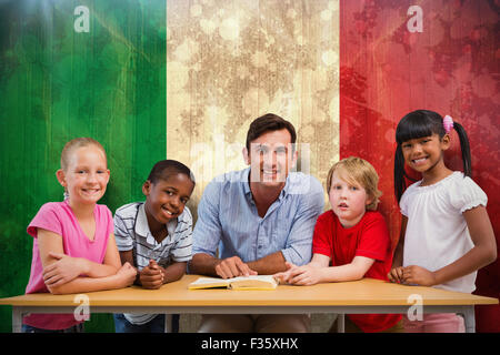 Immagine composita di insegnanti e alunni sorridente in telecamera in libreria Foto Stock