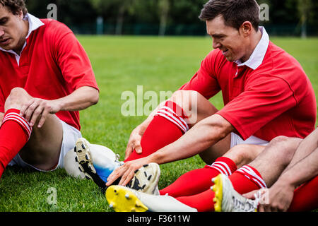 Giocatori di Rugby seduto sull'erba prima di match Foto Stock