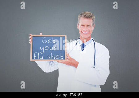 Immagine composita del ritratto di sorridente medico maschio azienda ardesia vuoto Foto Stock