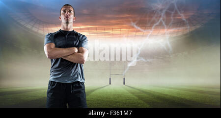 Immagine composita di piena lunghezza di fiduciosa giocatore di rugby con le braccia incrociate Foto Stock