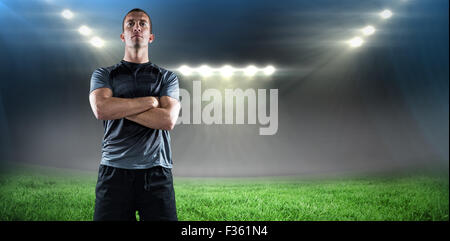 Immagine composita di piena lunghezza di fiduciosa giocatore di rugby con le braccia incrociate Foto Stock