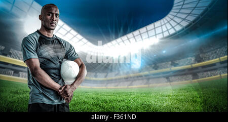 Immagine composita del ritratto di fiduciosa sportivo con palla da rugby Foto Stock