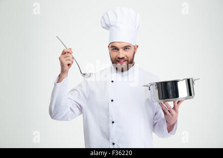 Ritratto di un maschio di chef di cucina in possesso di una pentola e la siviera isolato su uno sfondo bianco Foto Stock