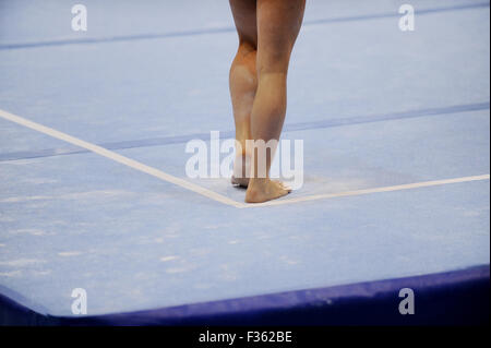 Piedi del ginnasta sono visibili sul pavimento esercizio durante il concorso di ginnastica Foto Stock