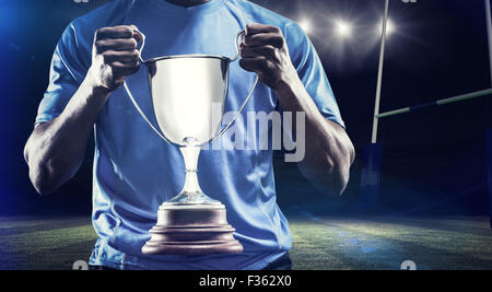 Immagine composita della sezione centrale della sportivo holding trophy Foto Stock