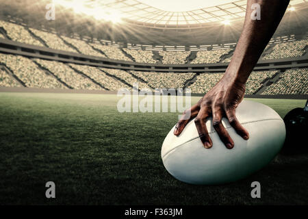 Immagine composita di immagine ritagliata di atleta tenendo palla da rugby Foto Stock