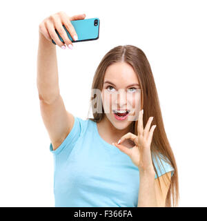 Bella giovane donna di scattare una foto della stessa con la sua fotocamera del telefono - isolato su sfondo bianco. Foto Stock