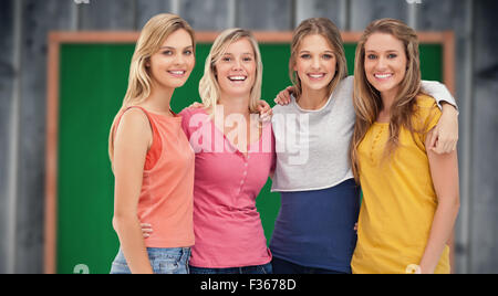 Immagine composita di quattro amici in piedi accanto a ciascun altro e sorridente Foto Stock