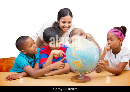 Immagine composita di graziosi gli alunni e gli insegnanti guardando il globo in biblioteca Foto Stock