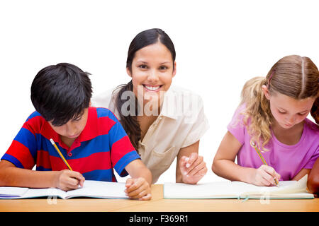 Immagine composita di pretty docente aiutare gli studenti nella libreria Foto Stock
