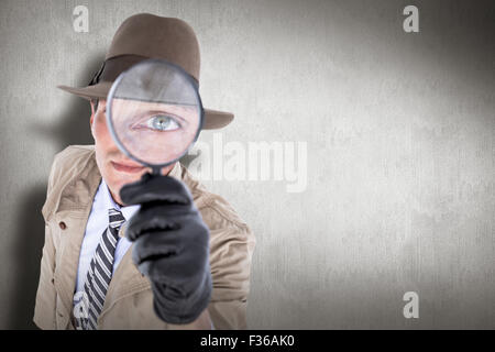 Immagine composita di spy guardando attraverso la lente di ingrandimento Foto Stock